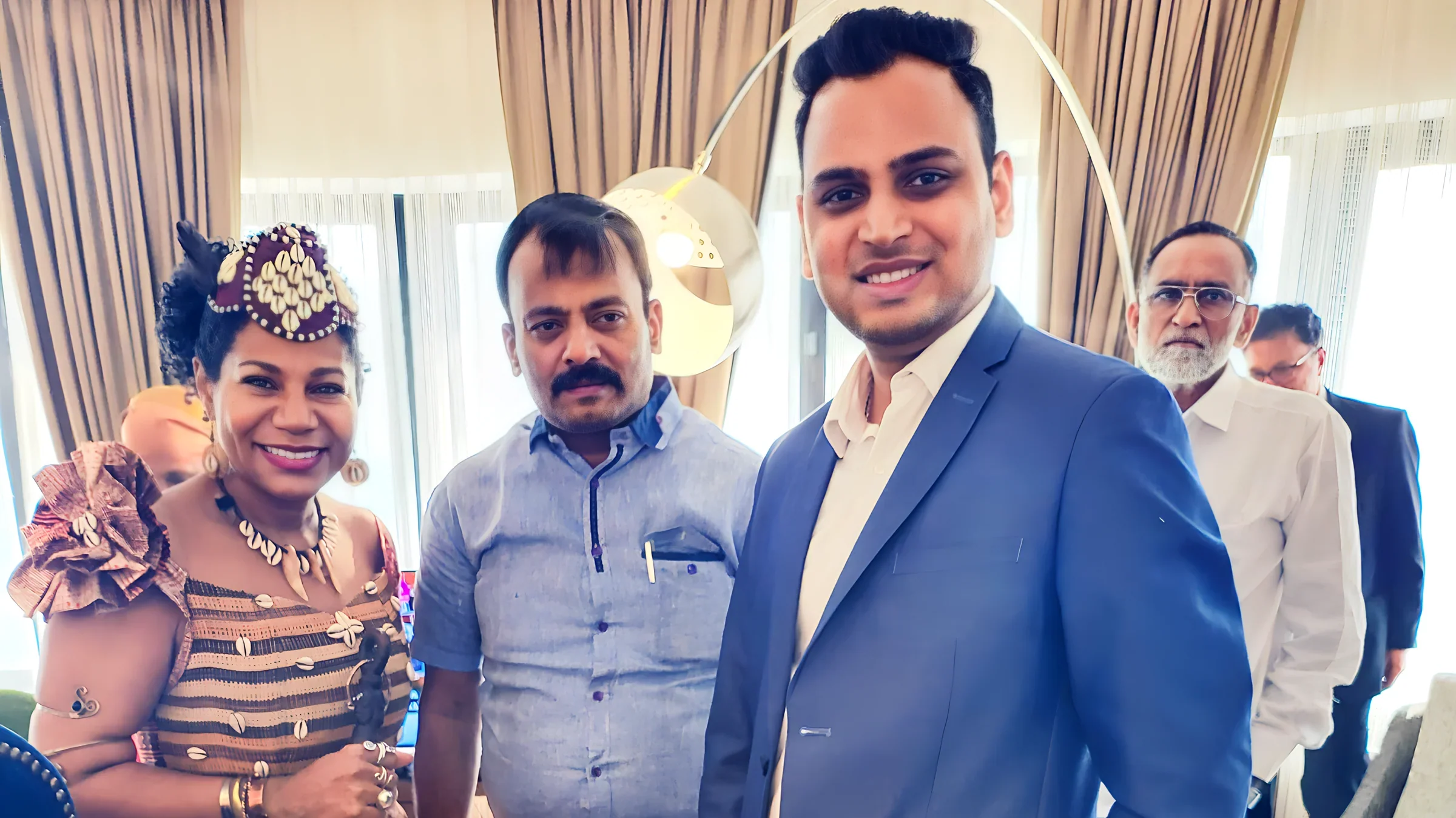 Lithvik Mukesh Sharma is photographed with Queen Diambi and a political leader at an indoor reception
